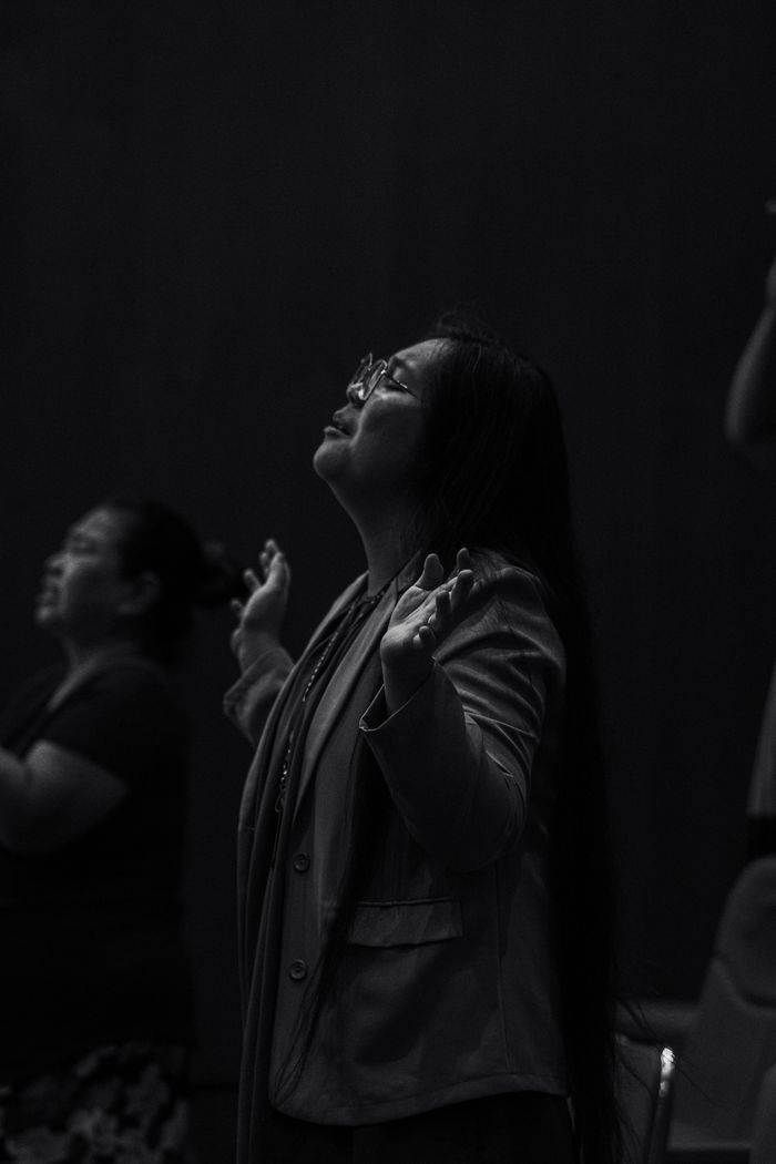 A group of women in deep spiritual worship, expressing devotion and praise.
